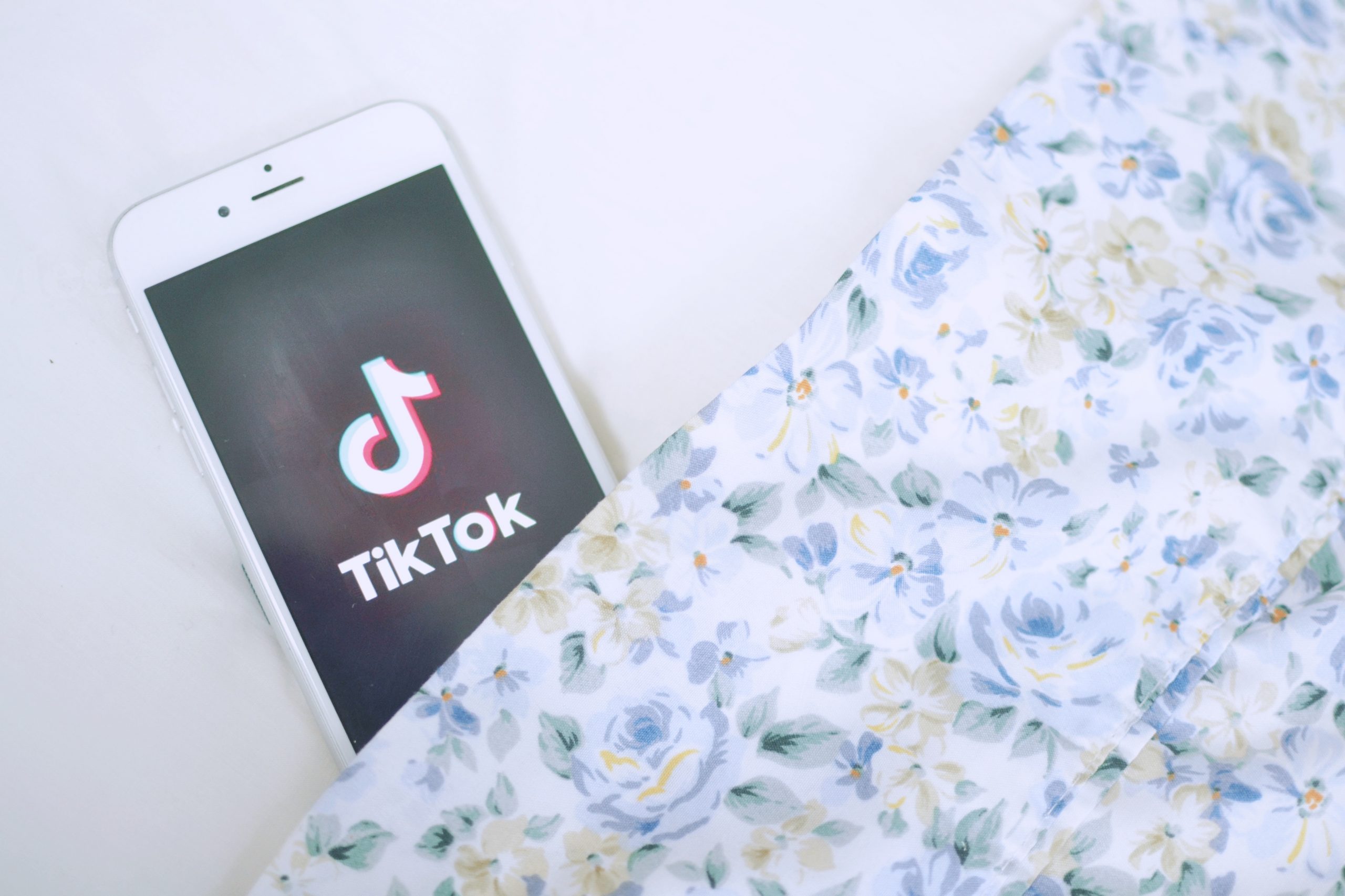 Floral Patter and phone displaying the app Tik Tok
