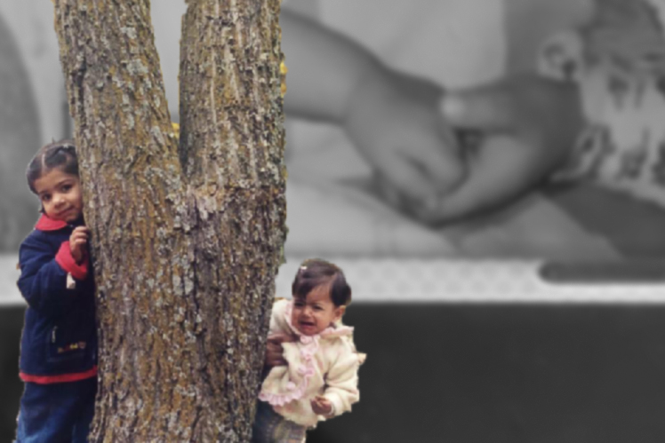 Picture of Khadija and Fatima with a tree in front of a picture of them holding hands.