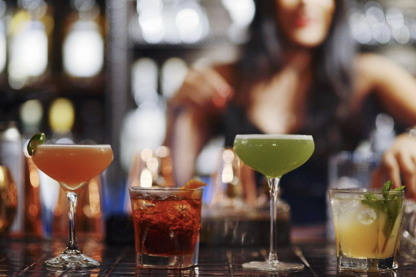 A bartender prepares four drinks